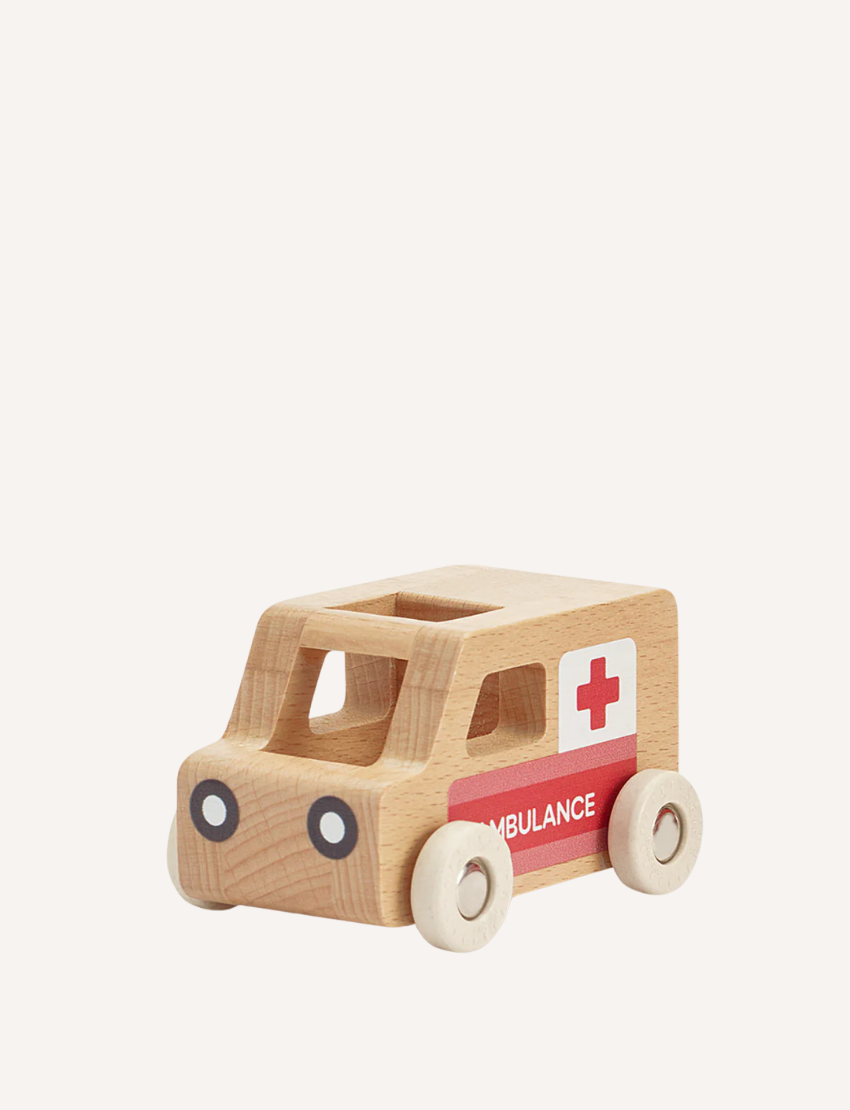 The Moover Mini Emergency Cars are simple wooden ambulances with white wheels, a red cross on the side, and "AMBULANCE" printed. They have a natural wood finish, non-toxic paints, and a rectangular cutout on top.