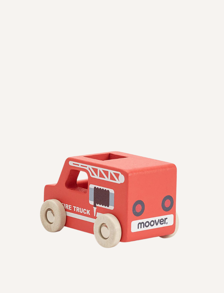 The Moover Mini Emergency Cars are simple wooden ambulances with white wheels, a red cross on the side, and "AMBULANCE" printed. They have a natural wood finish, non-toxic paints, and a rectangular cutout on top.