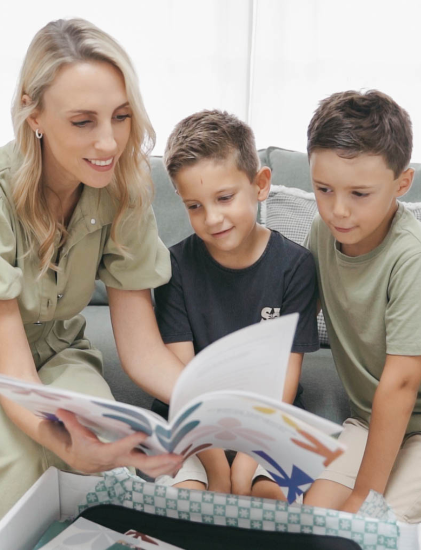 The Therapy At Home Handwriting in Practice Program includes a green and blue box with notebooks, pens, sticky notes, stickers, a pencil sharpener, planner sheets, a black carrying case, and a handwriting workbook for effective practice.