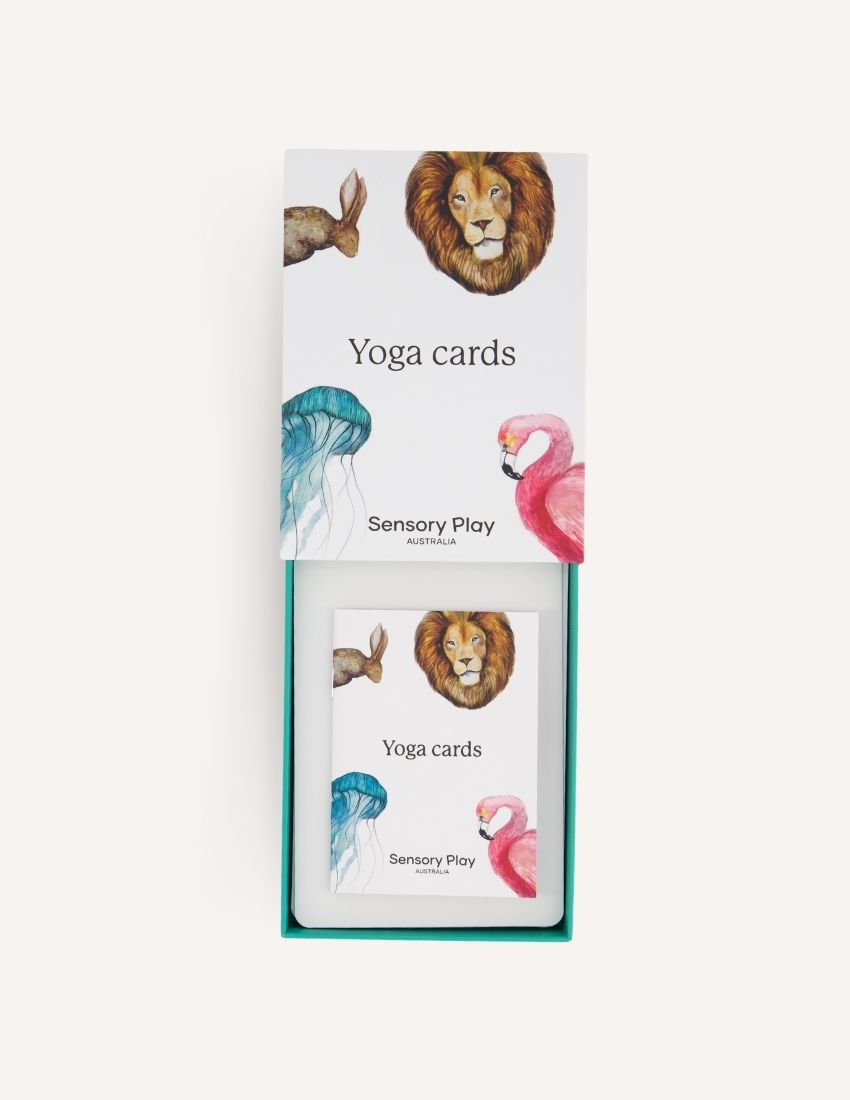 Introducing the "Yoga Cards Set in Box (SPA)" from Sensory Play Australia. The cover features delightful illustrations of a lion, kangaroo, jellyfish, and flamingo. Perfect for introducing mindfulness to kids, this set provides instructions, benefits, and colorful icons on the back of each card.