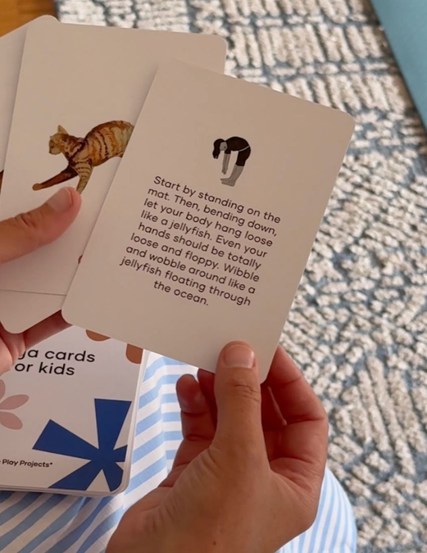 Introducing the "Yoga Cards Set in Box (SPA)" from Sensory Play Australia. The cover features delightful illustrations of a lion, kangaroo, jellyfish, and flamingo. Perfect for introducing mindfulness to kids, this set provides instructions, benefits, and colorful icons on the back of each card.