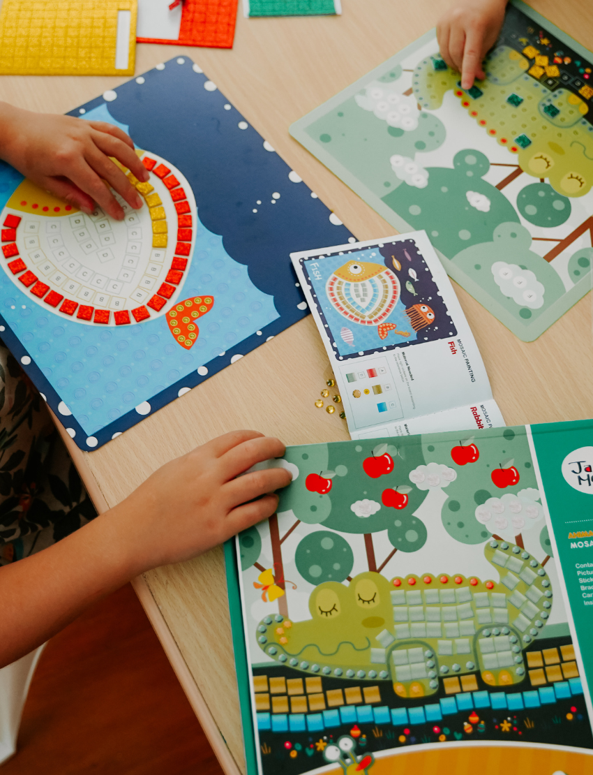 The Therapy At Home Handwriting in Practice Program includes a green and blue box with notebooks, pens, sticky notes, stickers, a pencil sharpener, planner sheets, a black carrying case, and a handwriting workbook for effective practice.