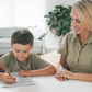 The Therapy At Home Handwriting in Practice Program includes a green and blue box with notebooks, pens, sticky notes, stickers, a pencil sharpener, planner sheets, a black carrying case, and a handwriting workbook for effective practice.