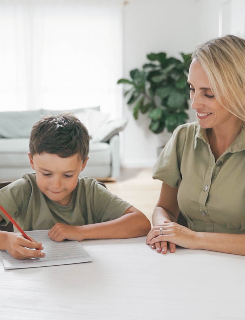 The Therapy At Home Handwriting in Practice Program includes a green and blue box with notebooks, pens, sticky notes, stickers, a pencil sharpener, planner sheets, a black carrying case, and a handwriting workbook for effective practice.