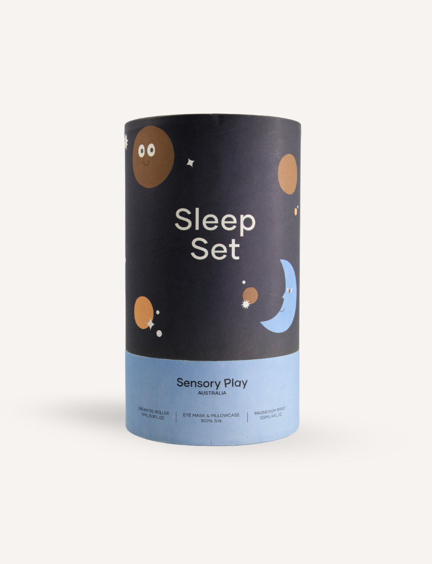 A round, light blue box labeled "Sensory Play Australia" contains the "Sleep Set," which includes a white cylindrical bottle labeled "Melo Dream," a brown spray bottle labeled "Melo," and a folded light blue fabric item, possibly an eye mask or pillowcase.