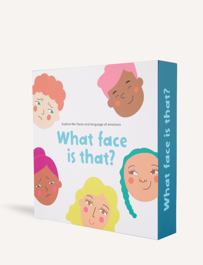 A box of the "What face is that? Game" by Sensory Play Australia is displayed. The front showcases illustrated, interactive faces conveying different emotions, while the side of the box features the title "What face is that?" printed vertically, encouraging kids to explore and role-play various feelings in an enjoyable and engaging manner.