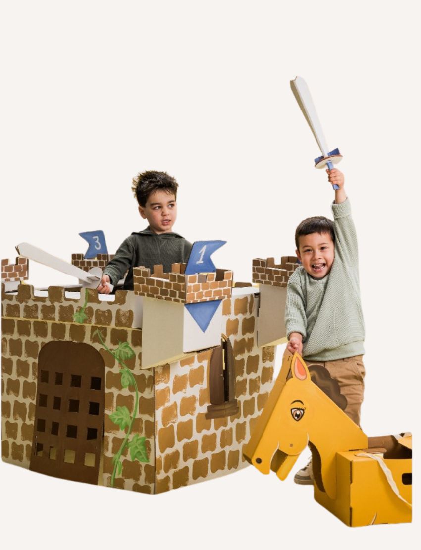 The Castle House by Les Petite Artistes is a straightforward, gray, cardboard model of a medieval-style castle. It boasts a crenelated top and four corner towers, along with an arched entrance adorned with a grid-like pattern at the front. The background is plain white.