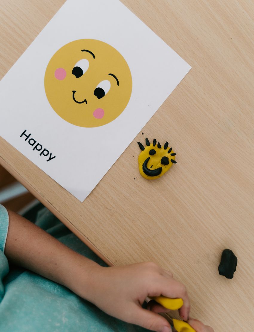 A box of the "What face is that? Game" by Sensory Play Australia is displayed. The front showcases illustrated, interactive faces conveying different emotions, while the side of the box features the title "What face is that?" printed vertically, encouraging kids to explore and role-play various feelings in an enjoyable and engaging manner.