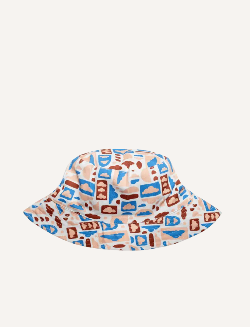 The IZIMINI Cotton Baby Hat is a vibrant bucket hat with a floral print of pink, orange, blue, and green leaves on white. Perfect for outdoor adventures with its wide brim and rounded top, it offers stylish sun protection.