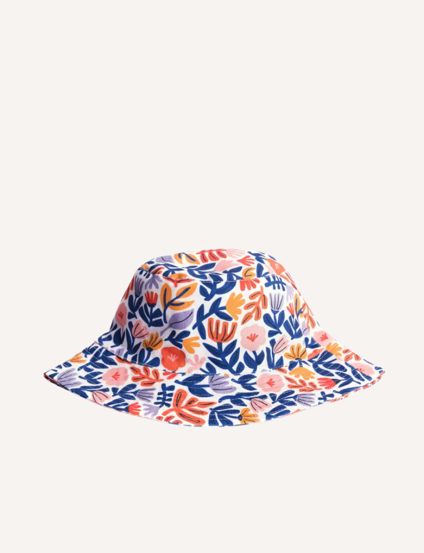 The IZIMINI Cotton Baby Hat is a vibrant bucket hat with a floral print of pink, orange, blue, and green leaves on white. Perfect for outdoor adventures with its wide brim and rounded top, it offers stylish sun protection.