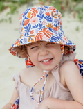 The IZIMINI Cotton Baby Hat is a vibrant bucket hat with a floral print of pink, orange, blue, and green leaves on white. Perfect for outdoor adventures with its wide brim and rounded top, it offers stylish sun protection.