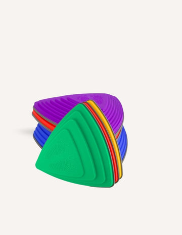 A stack of colorful Stepping Stones from Sensory Play Australia is displayed, perfect for children to develop their gross motor skills. The top stone features a green design with an embossed foot, followed by purple, red, blue, and yellow stones in descending order. These stones are ideal for children's play or physical activities.