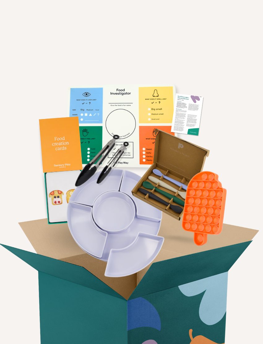 The image displays a set of educational and toy items from The Play Way's Food Exploration Kit, which includes colorful cards, a compartment tray, markers, a pop-it toy, rolling pins, a cutting tool, and a box. This kit appears to be crafted for sensory enjoyment and creative learning activities during mealtimes.