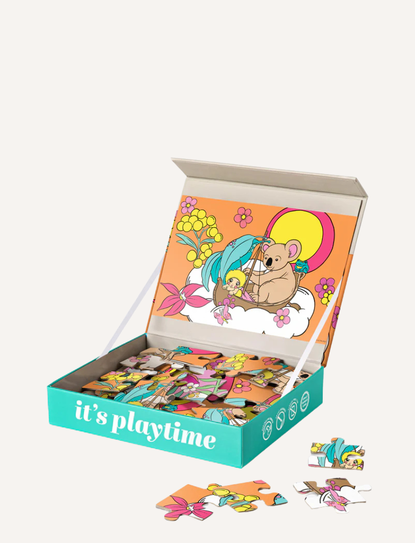 Open puzzle box with a koala and floral design, featuring partially assembled puzzle pieces inside.