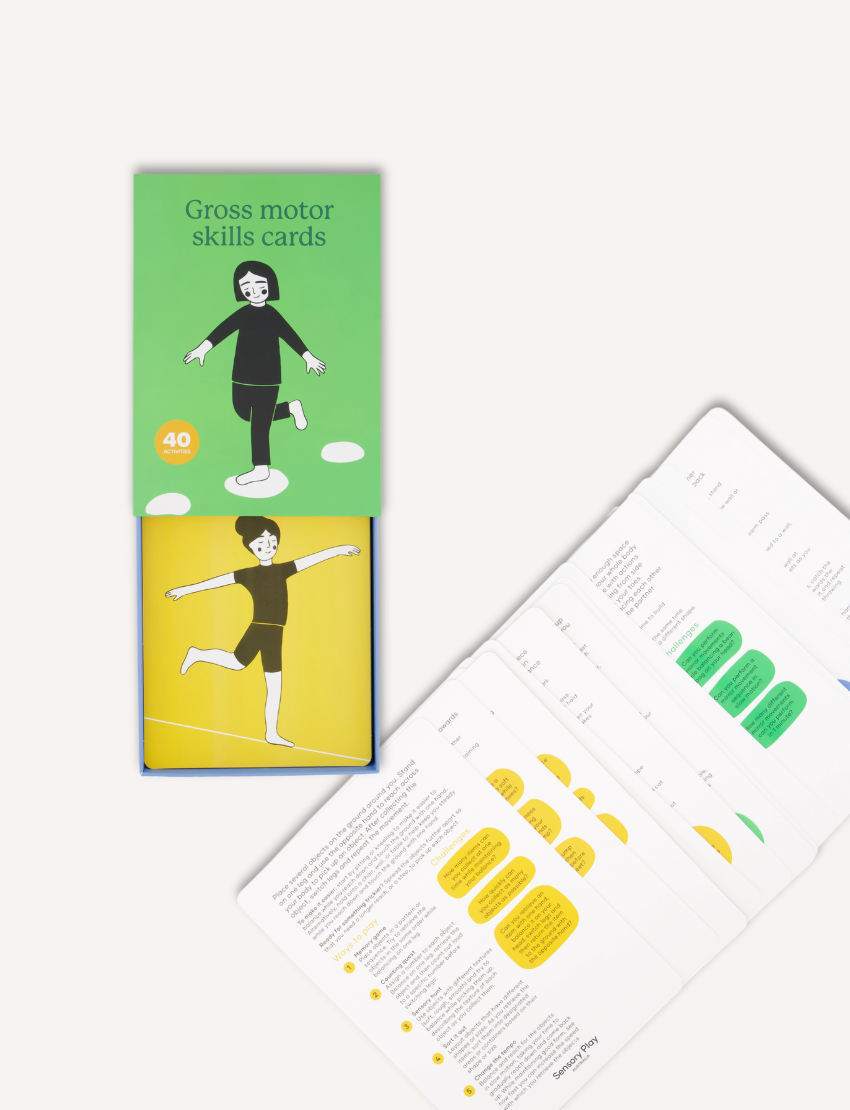 Two green boxes titled "Gross Motor Skills Cards Set" from Sensory Play Australia focus on physical development. The smaller box is on the left, while the larger one with a stepping-stones illustration is on the right. Each contains 40 cards designed to improve gross motor skills.