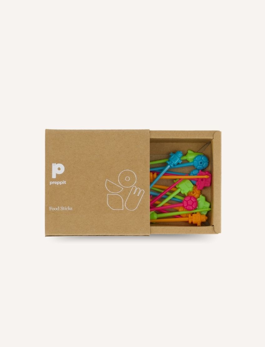 The Play Way's Family Meal and Food Sharing Kit features a cardboard box with a colorful design that opens to reveal various items, including a compartmentalized plastic tray, two sculpting tools, a set of food memory cards for sensory play, and a small box containing multicolored rubber bands.