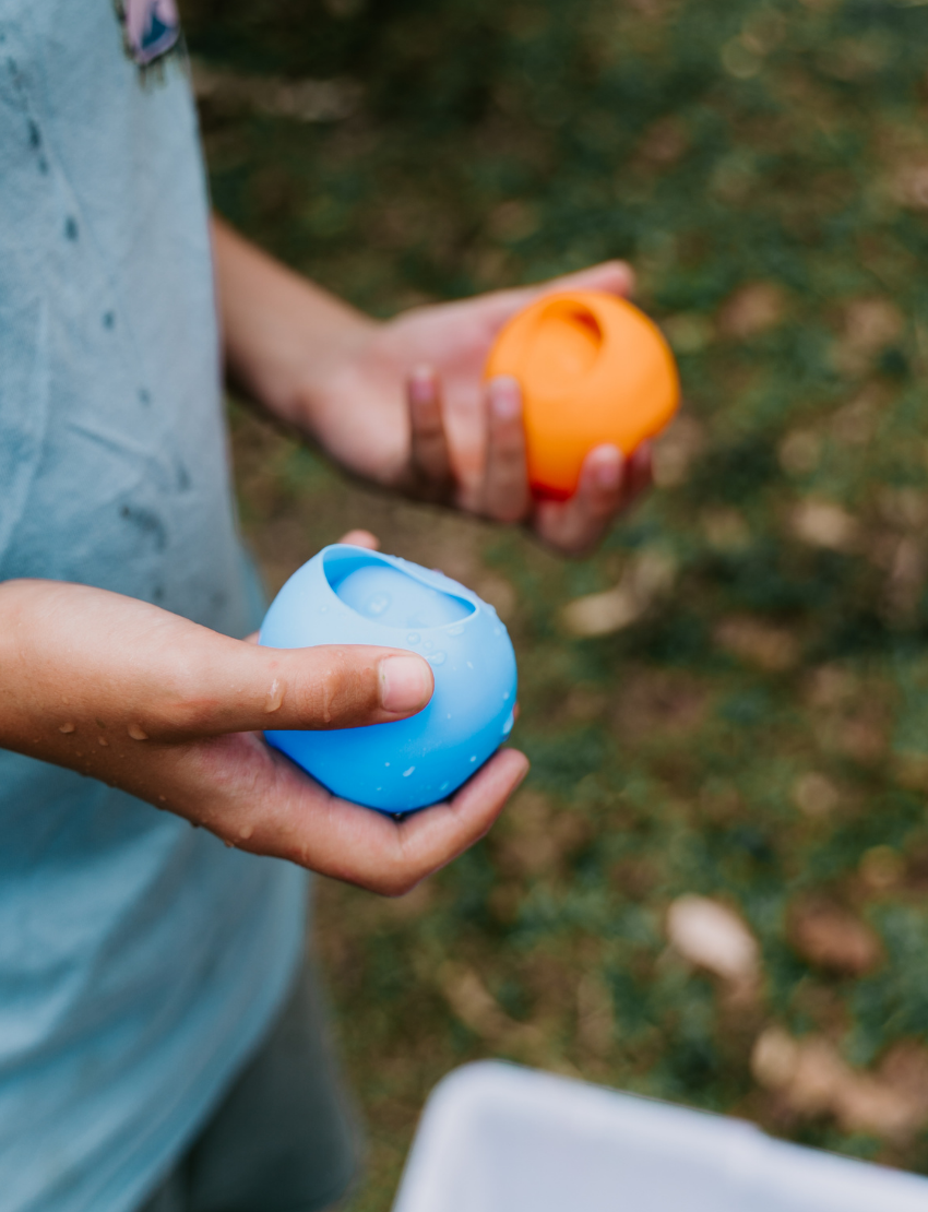 A white rectangular box with colorful circles features the text "Reusable Water Balloons" prominently. The eco-friendly package by Sensory Play Australia is set against a simple, light background.