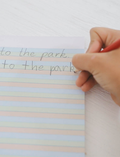 The Sky, Grass, Dirt Writing Pad - A4 by Sensory Play Australia features a light blue cover with abstract dark blue wavy lines. Ideal for handwriting practice.