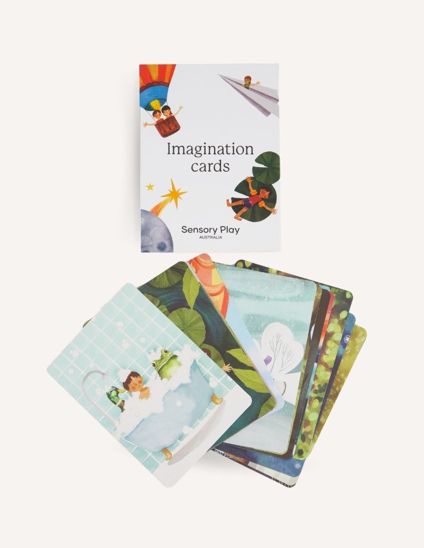 Two white boxes labeled "Imagination Cards Set in Box" by Sensory Play Australia are shown. The larger box is on the right, and the smaller box is on the left. The boxes feature illustrations of children engaging in imaginative activities, perfect for enhancing storytelling skills with a colorful background.