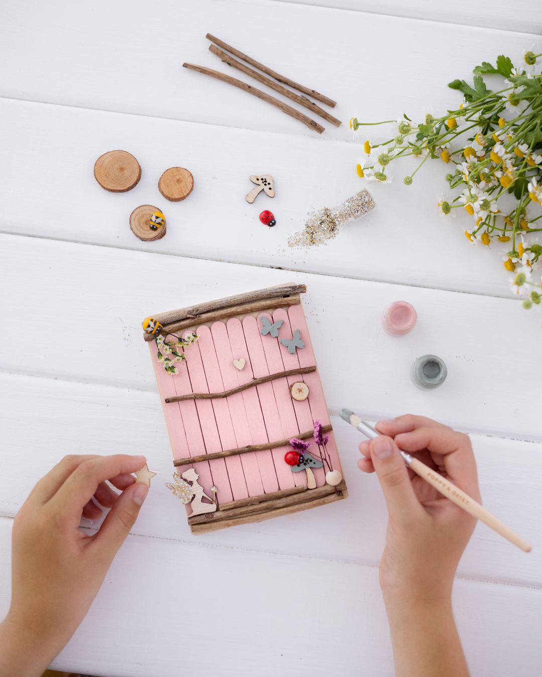 Two children playing with a cardboard castle and unicorn carriage