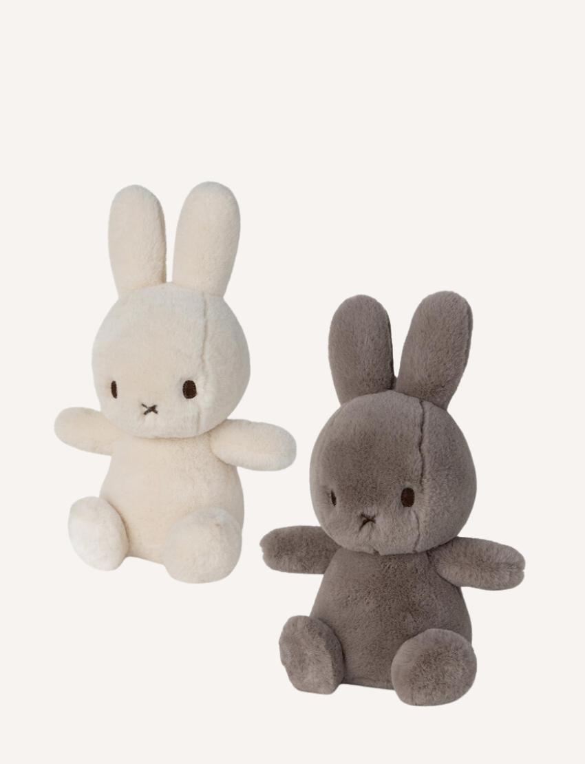 Two cute Miffy plush toys, one cream and one grey, sitting side-by-side on a neutral background.
