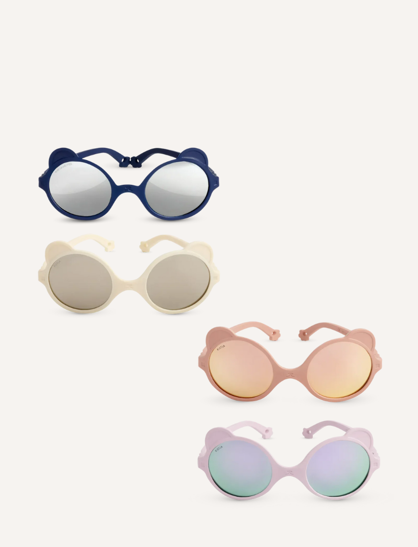 Four pairs of trendy OURS'ON sunglasses by Ki ET LA for ages 2-4 are stylish and safe: dark blue with UV reflective lenses, cream with beige lenses, pink with rose-tinted lenses, and lilac with light blue lenses—perfect for kids' fashion.