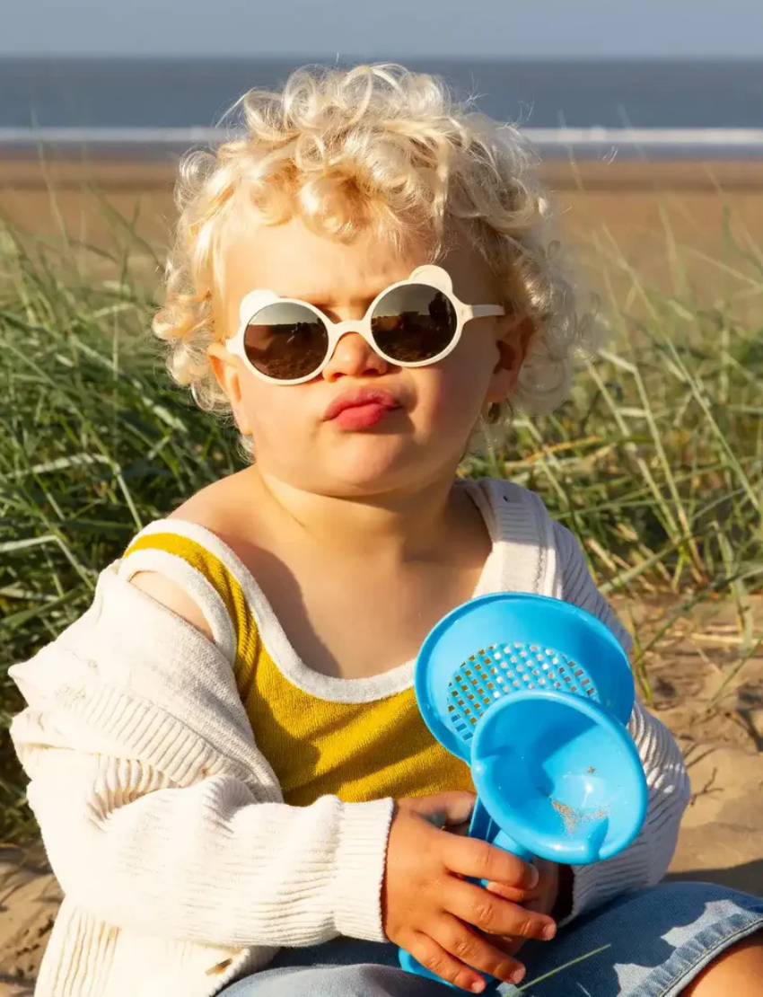 Four pairs of trendy OURS'ON sunglasses by Ki ET LA for ages 2-4 are stylish and safe: dark blue with UV reflective lenses, cream with beige lenses, pink with rose-tinted lenses, and lilac with light blue lenses—perfect for kids' fashion.