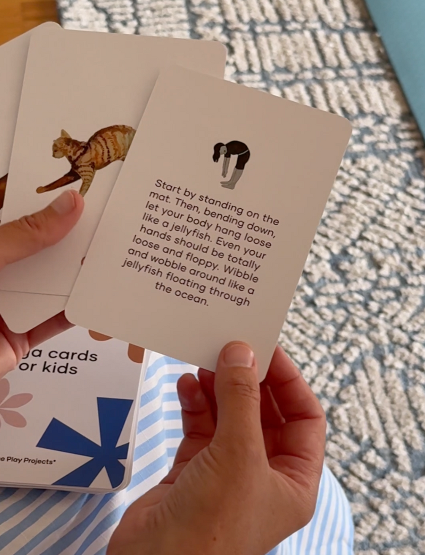 The Yoga & Mindfulness Program by Therapy At Home features an open teal box with abstract designs, holding a yoga mat, teal cushion, books, cards, and small items—perfect for home yoga and mindfulness—displayed upright against a simple background.