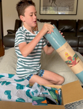 The Yoga & Mindfulness Program by Therapy At Home features an open teal box with abstract designs, holding a yoga mat, teal cushion, books, cards, and small items—perfect for home yoga and mindfulness—displayed upright against a simple background.