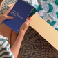 The Yoga & Mindfulness Program by Therapy At Home features an open teal box with abstract designs, holding a yoga mat, teal cushion, books, cards, and small items—perfect for home yoga and mindfulness—displayed upright against a simple background.