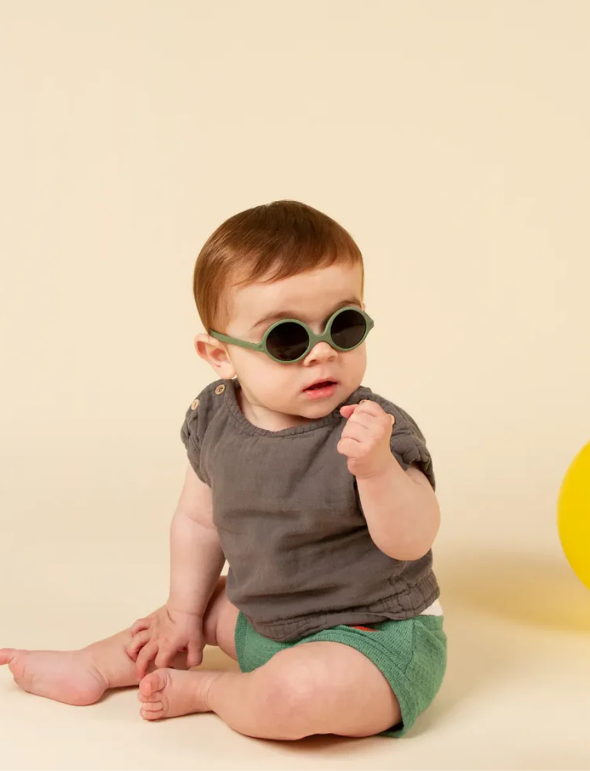 Three pairs of Ki ET LA DIABOLA baby sunglasses (0-1 year old) with total UV protection are stacked vertically: pink on top, green in the middle, and blue at the bottom. Each pair features thick frames and an identical design for optimal style and safety.