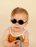 Three pairs of Ki ET LA DIABOLA baby sunglasses (0-1 year old) with total UV protection are stacked vertically: pink on top, green in the middle, and blue at the bottom. Each pair features thick frames and an identical design for optimal style and safety.