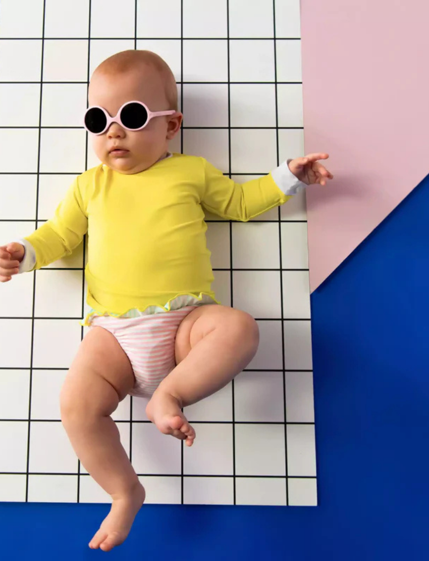 Three pairs of Ki ET LA DIABOLA baby sunglasses (0-1 year old) with total UV protection are stacked vertically: pink on top, green in the middle, and blue at the bottom. Each pair features thick frames and an identical design for optimal style and safety.