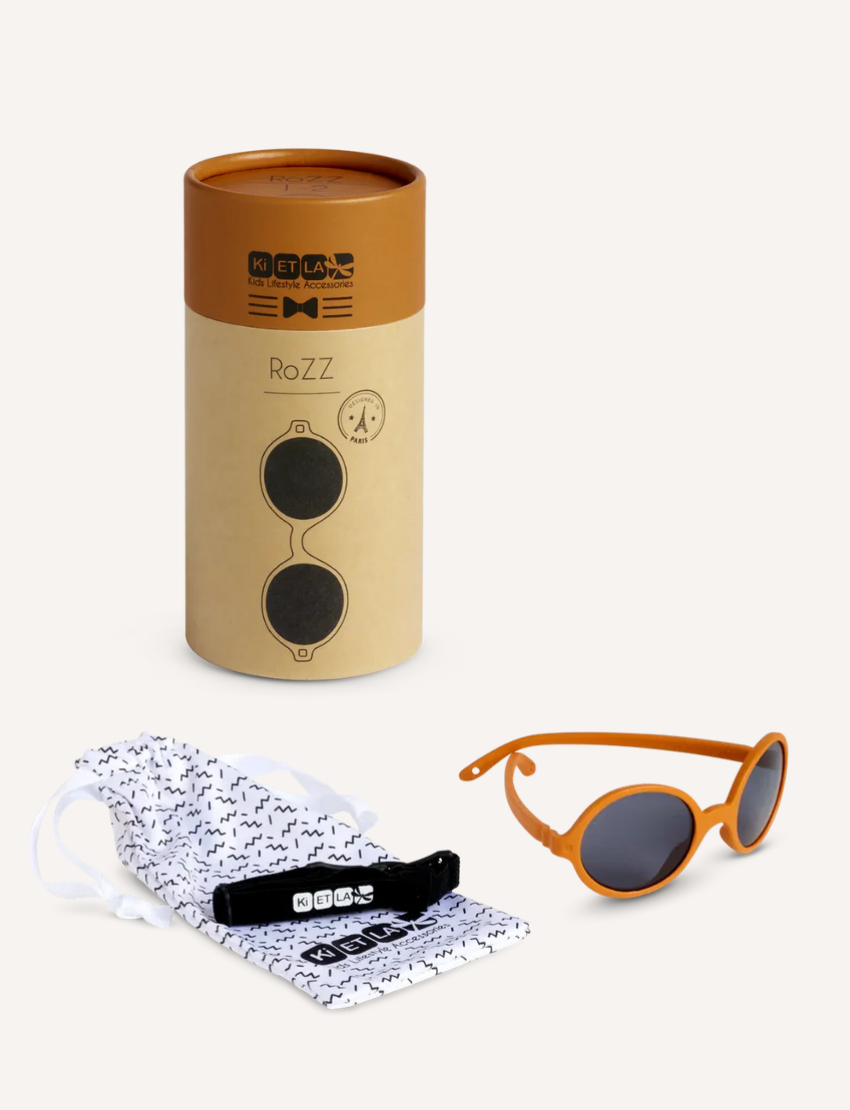 Two pairs of round sunglasses are shown against a plain backdrop. The top pair offers unbreakable frames with polarised lenses for durability, and the bottom pair features vibrant orange frames with dark lenses, ideal for children aged 2-4 years old. Brand: Ki ET LA, Product: ROZZ Sunglasses.