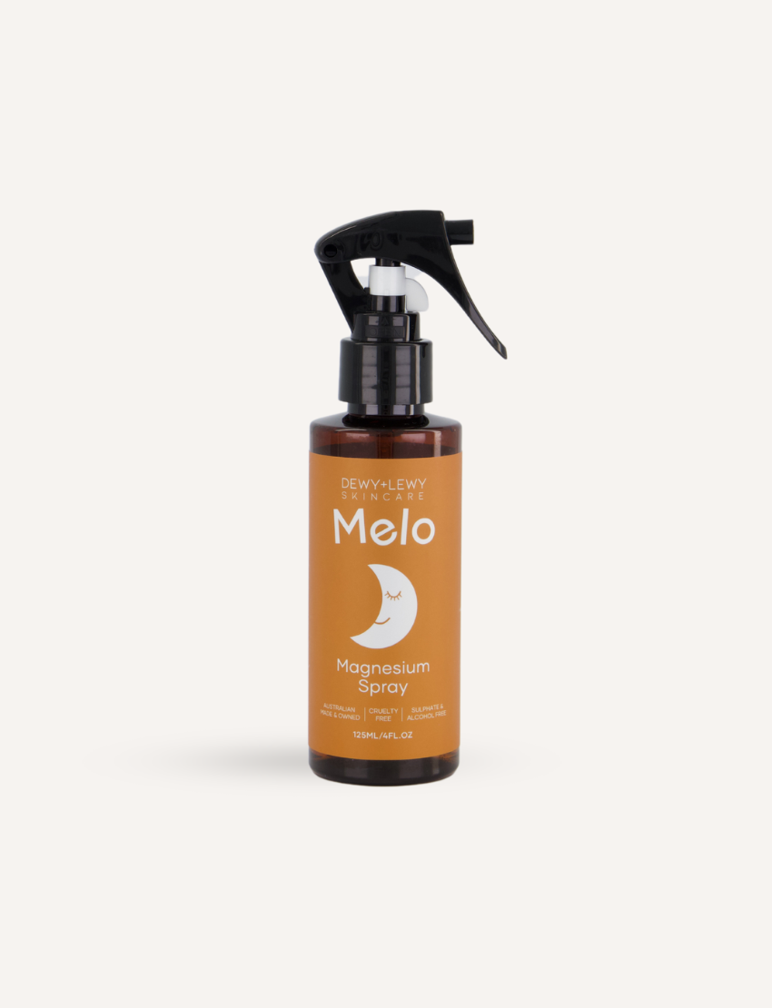 A 125 mL bottle of Melo Magnesium Sleep Spray with a black spray top. The label is orange with text that reads "DEWY+LEWY SKINCARE," "Melo," "Magnesium Sleep Spray," and additional benefits and usage information. The label features a white crescent moon design.