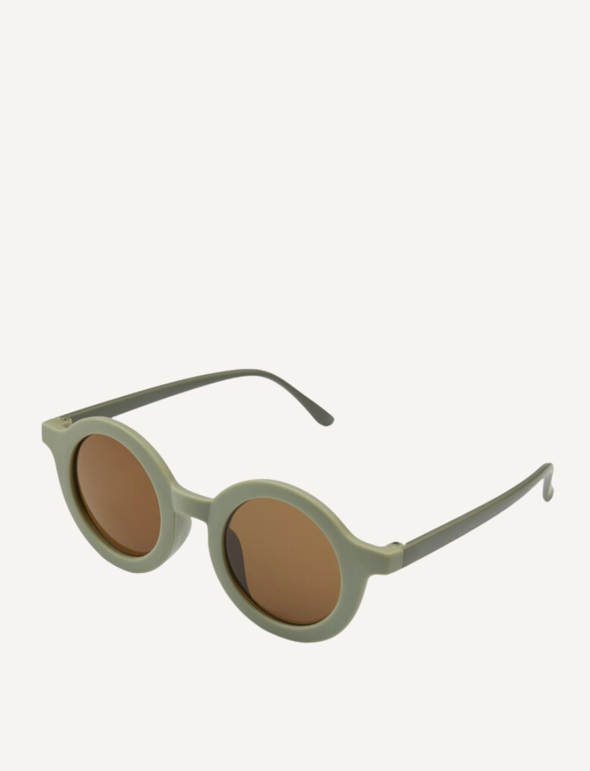 Anna Sunglasses by Nuuroo, featuring dusty green round frames and brown polycarbonate lenses, are displayed on a plain white background. They have thin, slightly curved arms and offer UV400 protection, ideal for children.