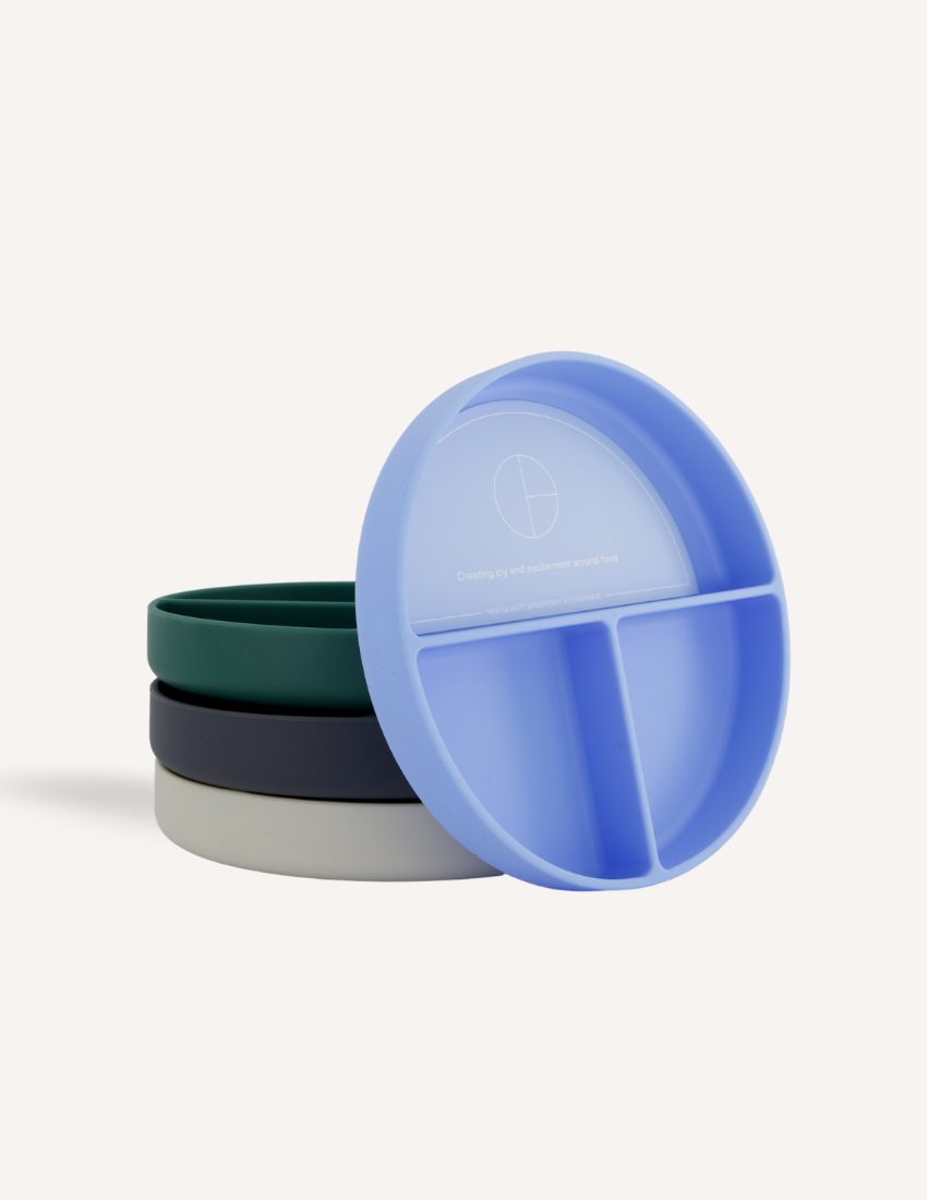 Stack of colorful silicone plates and bowls, featuring a divided plate.