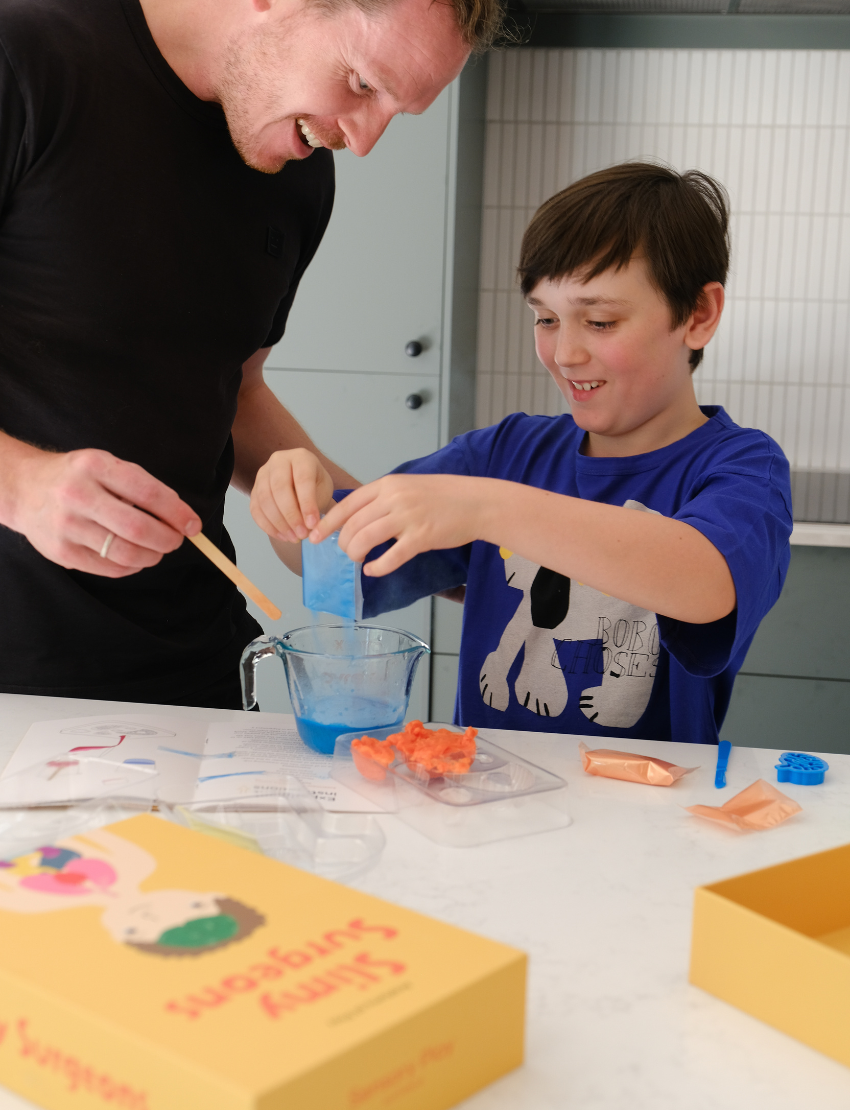 The yellow Slimy Surgeons box by Sensory Play Australia displays its title in red and features an illustrated person with visible brain and organs, marked as suitable for ages 8+.