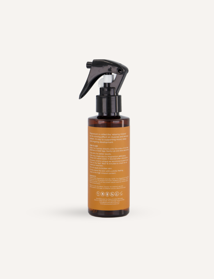 A 125 mL bottle of Melo Magnesium Sleep Spray with a black spray top. The label is orange with text that reads "DEWY+LEWY SKINCARE," "Melo," "Magnesium Sleep Spray," and additional benefits and usage information. The label features a white crescent moon design.