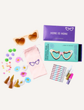 Two boxed craft kits feature a teal pair with heart-shaped sunglasses and a yellow pair with flower-shaped sunglasses. Both are labeled 