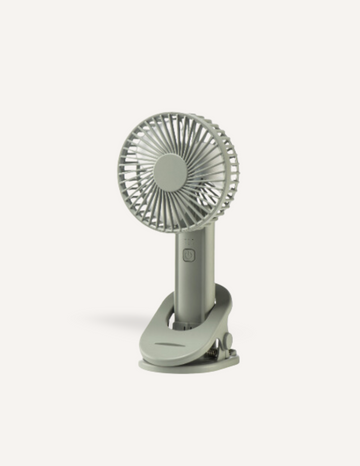 A small, gray, Sensory Play Australia Sleep Fan with a circular blade guard and a clip base stands upright on a white background. This portable fan produces gentle white noise and features a power button on the front, making it perfect for creating a calming atmosphere.