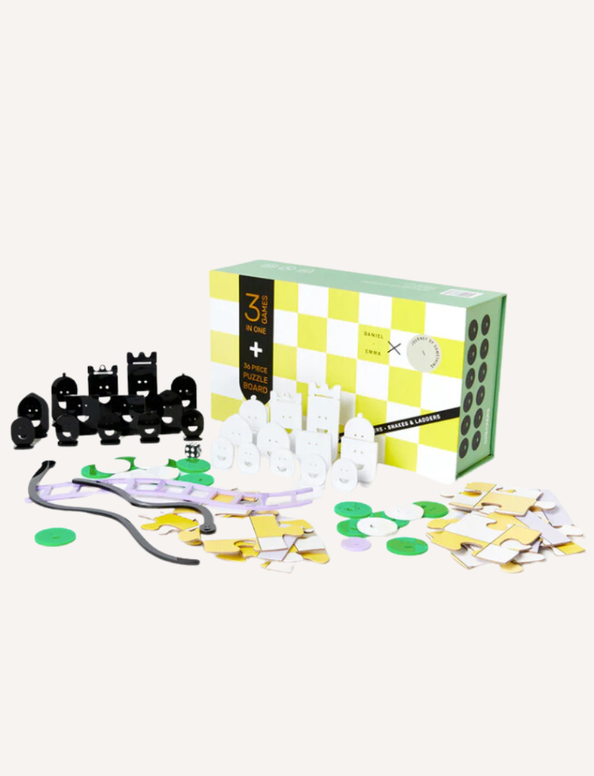 Experience the 3 in 1 Game Set by Journey of Something, featuring a chess and checkers set with black and white magnetic pieces adorned with faces. It comes with a green and white checkered box, a black carrying pouch, as well as flat round and cross-shaped pieces. The set also includes green coins and various square tiles for enhanced gameplay.