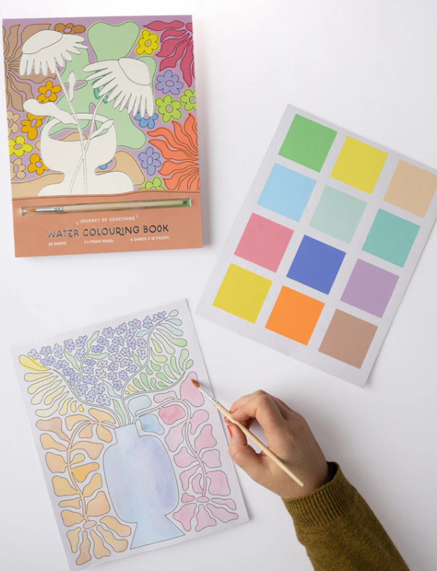 The "Watercolour Painting Book" from Journey of Something is paired with an open page displaying a floral design. The cover showcases abstract white hands, a vase, and colorful flowers on a pastel background. It includes 20 sheets and 6 papers.