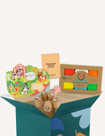 A box of the Fine Motor Practice: Playdough Kit by The Play Way, containing colorful playdough tubes and wooden stamps with various designs for creative expression, along with a booklet titled "Playdough Stamps." The box is adorned with abstract shapes and partially opened to reveal these sensory engagement tools, which are designed to enhance fine motor skills.