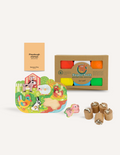 A box of the Fine Motor Practice: Playdough Kit by The Play Way, containing colorful playdough tubes and wooden stamps with various designs for creative expression, along with a booklet titled 