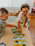 A large green box contains children's art supplies designed to foster creative expression: it features the Jar Melo Fine Motor Practice: Puzzle and Art Kit, which includes a pack of Giant Finger Paint Paper with a blue octopus and yellow crocodile, a Dot Painting Kit filled with colorful dots, and animal-themed tools that enhance fine motor skills.