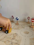 The image showcases Moover's Mini Car Sets, eco-friendly wooden toy vehicles including an electric car with solar panel, food truck, and road service vehicle. Ideal for role play, it also features signs like speed limit, stop sign, and exclamation mark warning.