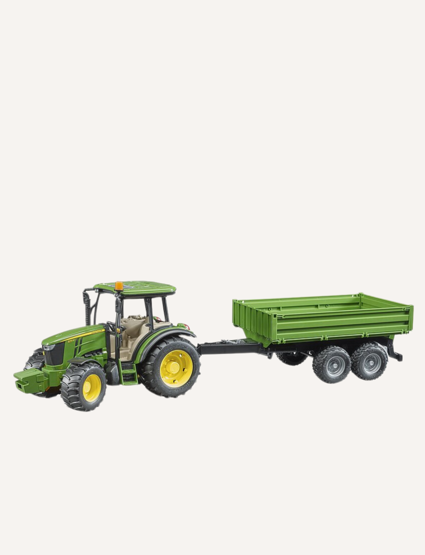 Green John Deere tractor with a trailer, shown from the side.