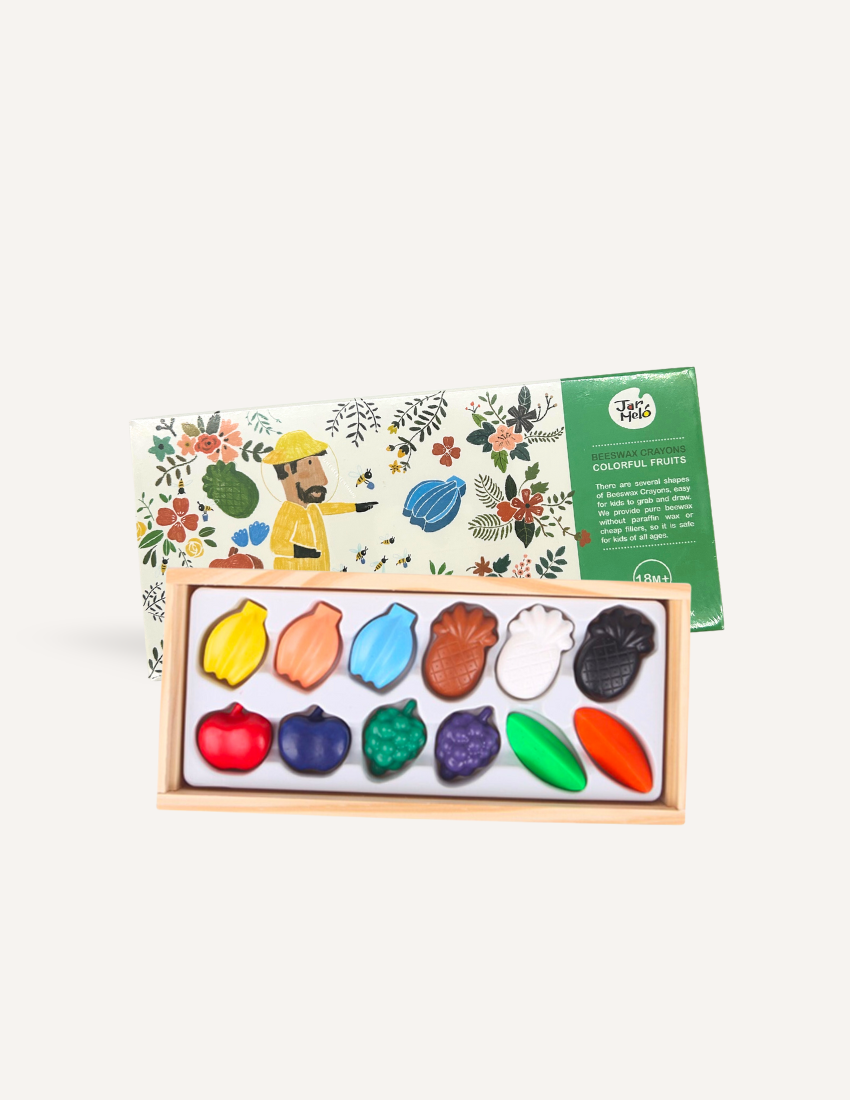 The Play Way's Jar Melo fruit-shaped beeswax crayons in a wooden tray, perfect for nurturing fine motor skills and creative expression.