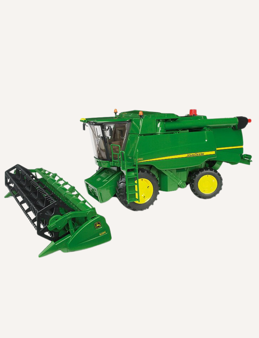 A Bruder John Deere Combine Harvester in green, complete with yellow wheels, is showcased with its header detached and positioned beside it. This T 670i model features a meticulously detailed exterior that captures the essence of traditional agricultural machinery.